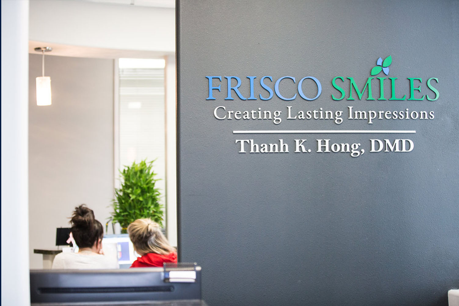 The image shows an interior space with a sign on a wall advertising  Fresco Smiles,  which appears to be a dental practice specializing in creating lasting impressions, and includes text that mentions  Thank K. Hong, DMD.