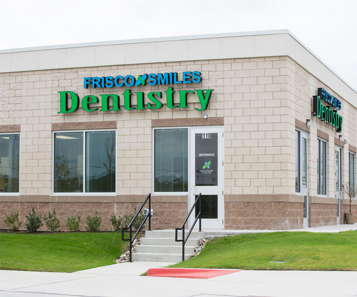 The image shows a dental clinic named  Fresco Smiles Dentistry  with a sign on its exterior.