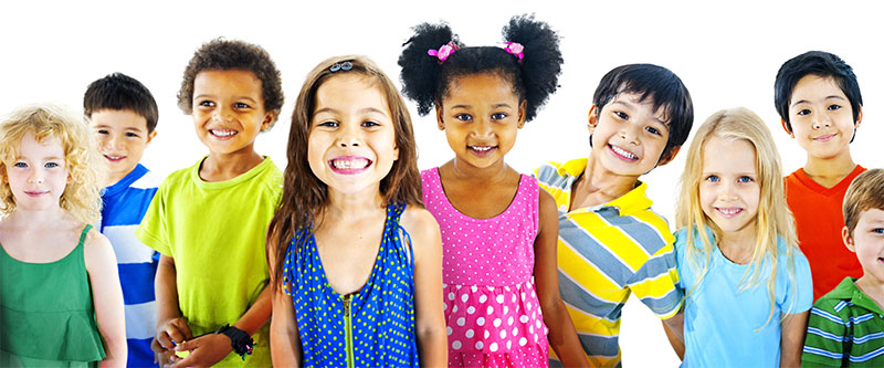 A group of children posing together with big smiles, each wearing different colored shirts.